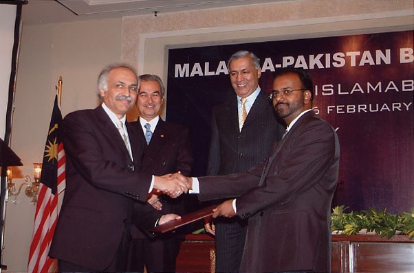 The signing of the Memorandum of Understanding between NPO Pakistan and Belmah Strategies, 16 February 2005, in front of a Malaysia-Pakistan backdrop in Islamabad.